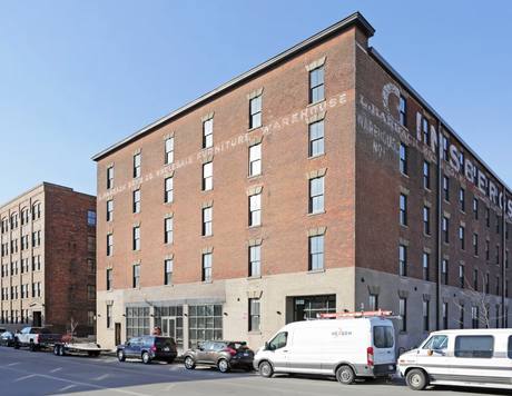 The original brick facade, with 'L. Harbach Sons Co. Wholesale Furniture Warehouse' still hand-painted on the wall