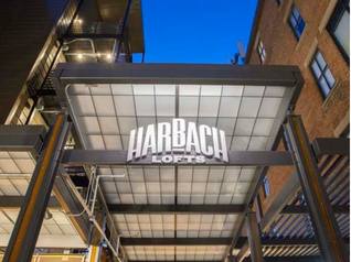The Harbach Lofts sign lit up at dusk