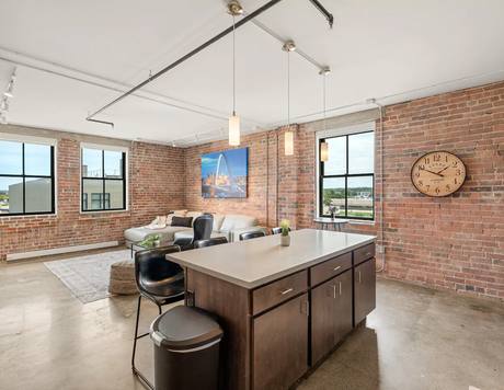 A home's kitchen and living space, original brick and factory windows